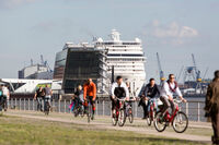 Radfahrer an der Elbe mit Kreuzfahrschiff im Hintergrund   © Mediaserver Hamburg   Jörg Modrow