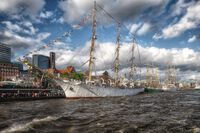 Blick von der Elbe zu den Landungsbrücken, wo drei traditionelle Segeschiffe liegen   © Mediaserver Hamburg   Andreas Vallbracht