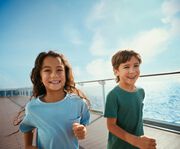 Kinder laufen freudig an der Reling entlang – © TUI Cruises