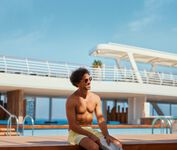 Mann entspannt am Pool – © TUI Cruises